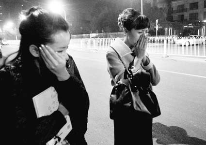 图为在事故现场，女司机（右）掩面而泣，受轻伤的出租车乘客站在旁边