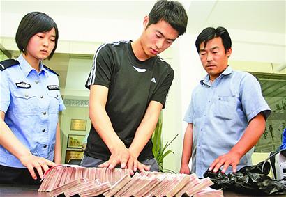 当着民警和的哥刘洪山的面，小王清点了自己遗失的四十万现金。